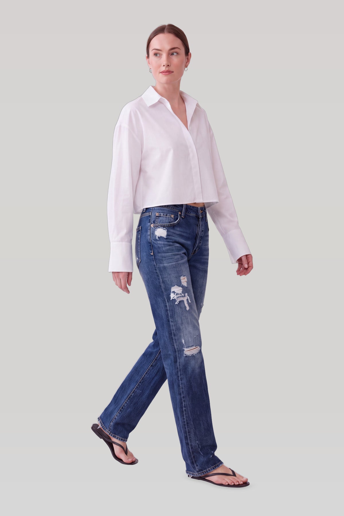 Mørkeblå straight jeans med slid, set fra siden i bevægelse