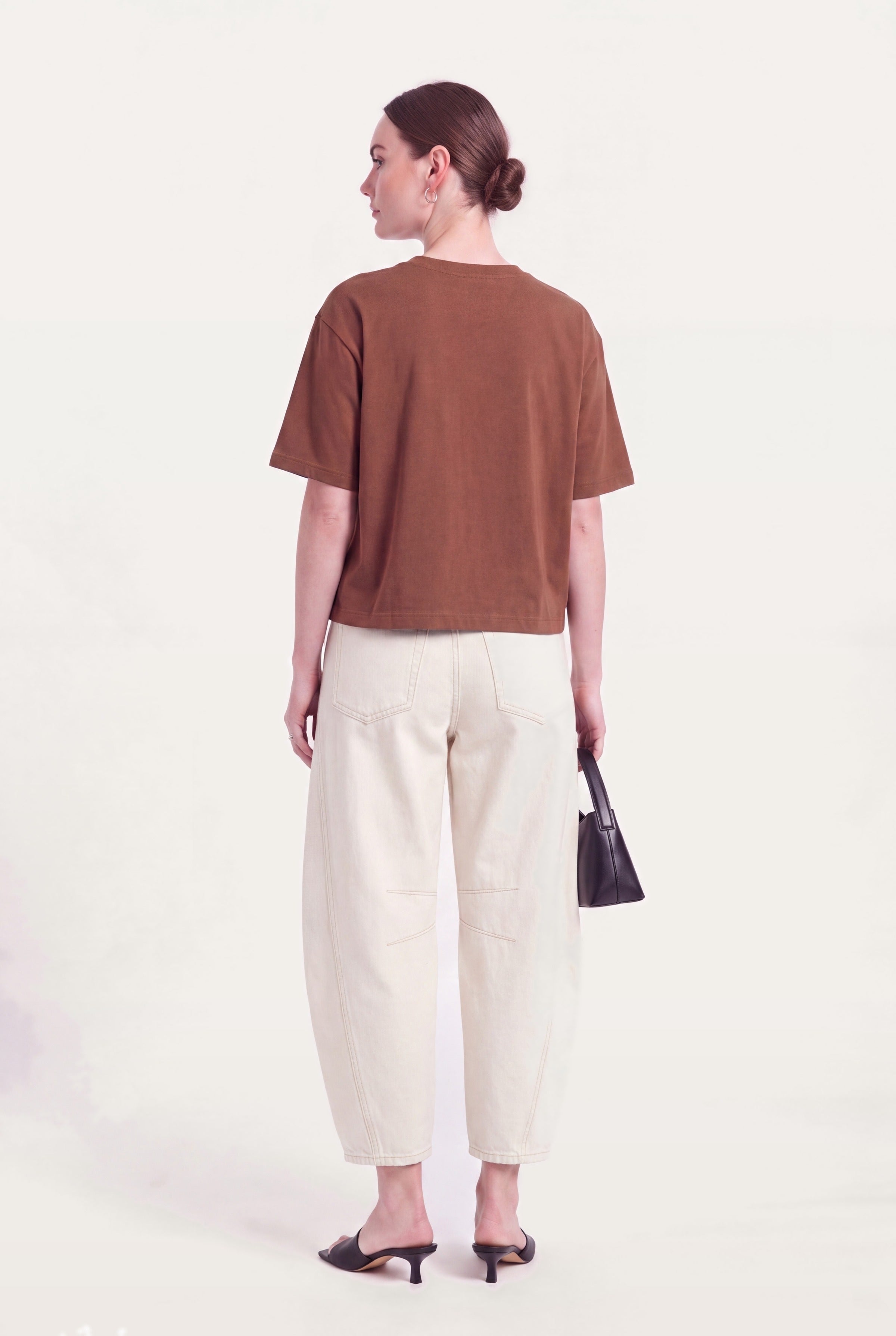 Barrel leg jeans dame i hvid denim set bagfra styles med brun top og hæle