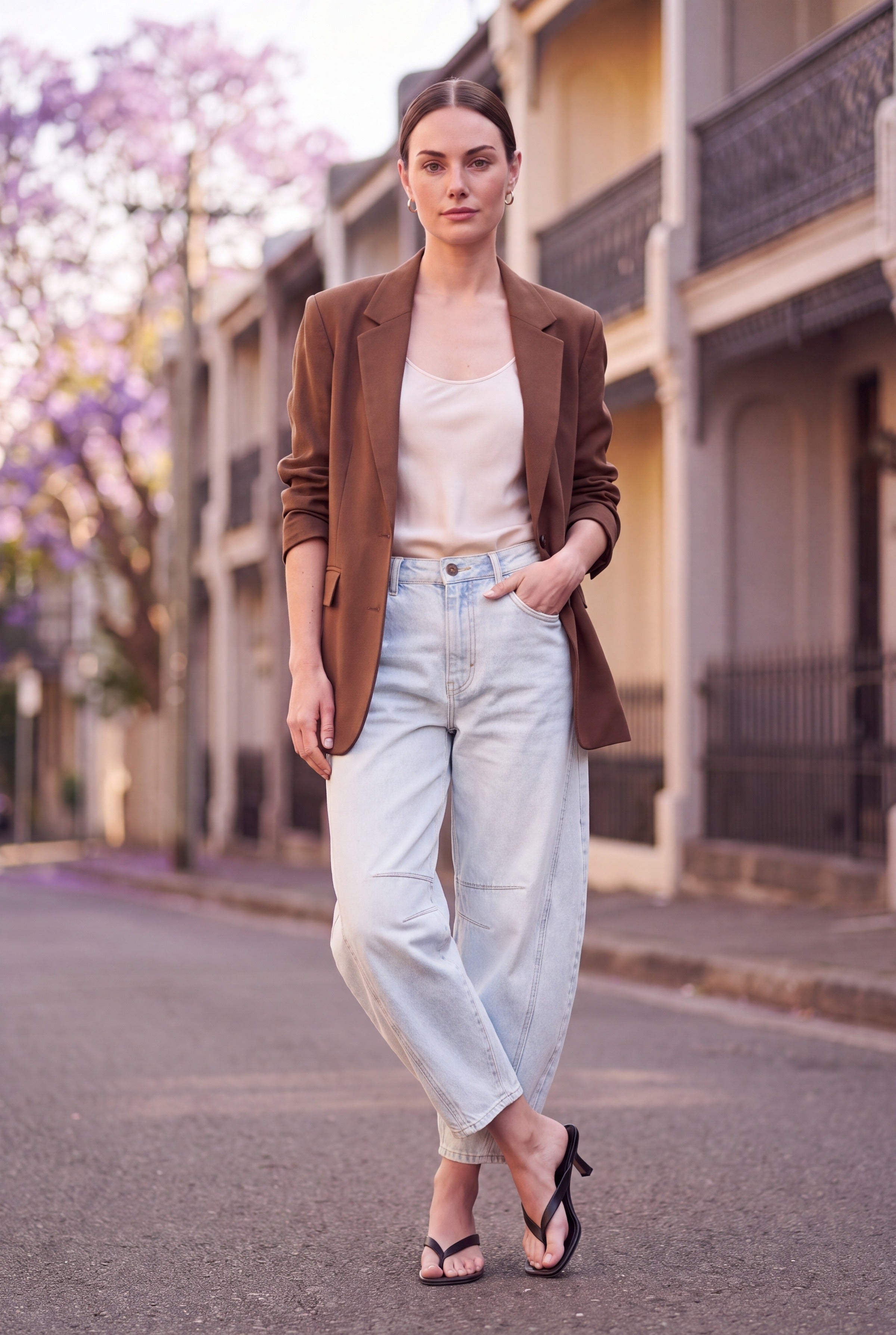 Barrel leg jeans dame i lyseblå denim styles med brun blazer og creme silketop