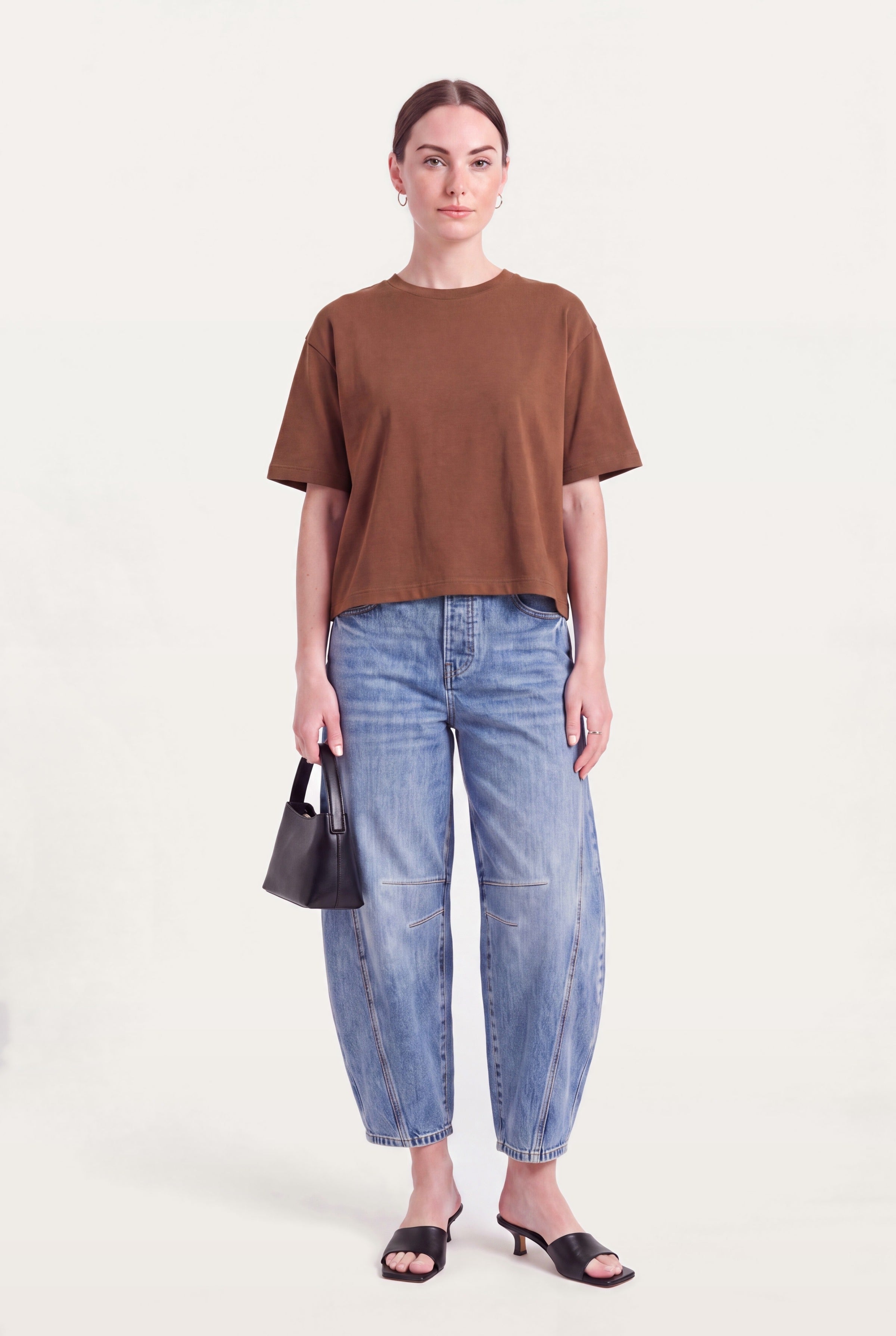 Barrel leg jeans dame styles med brun top, lille taske og hæle