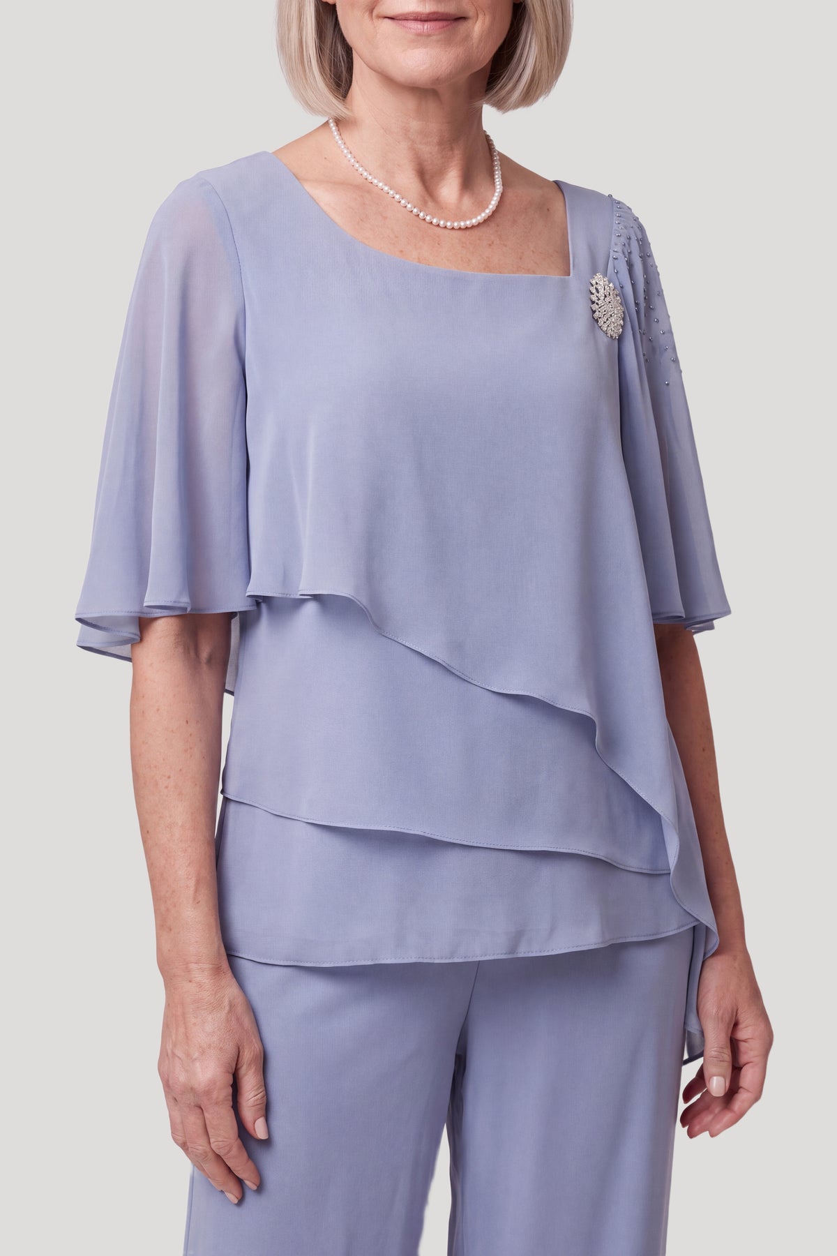 Lyseblå chiffon tunika med tre asymmetriske lag, halvfigur