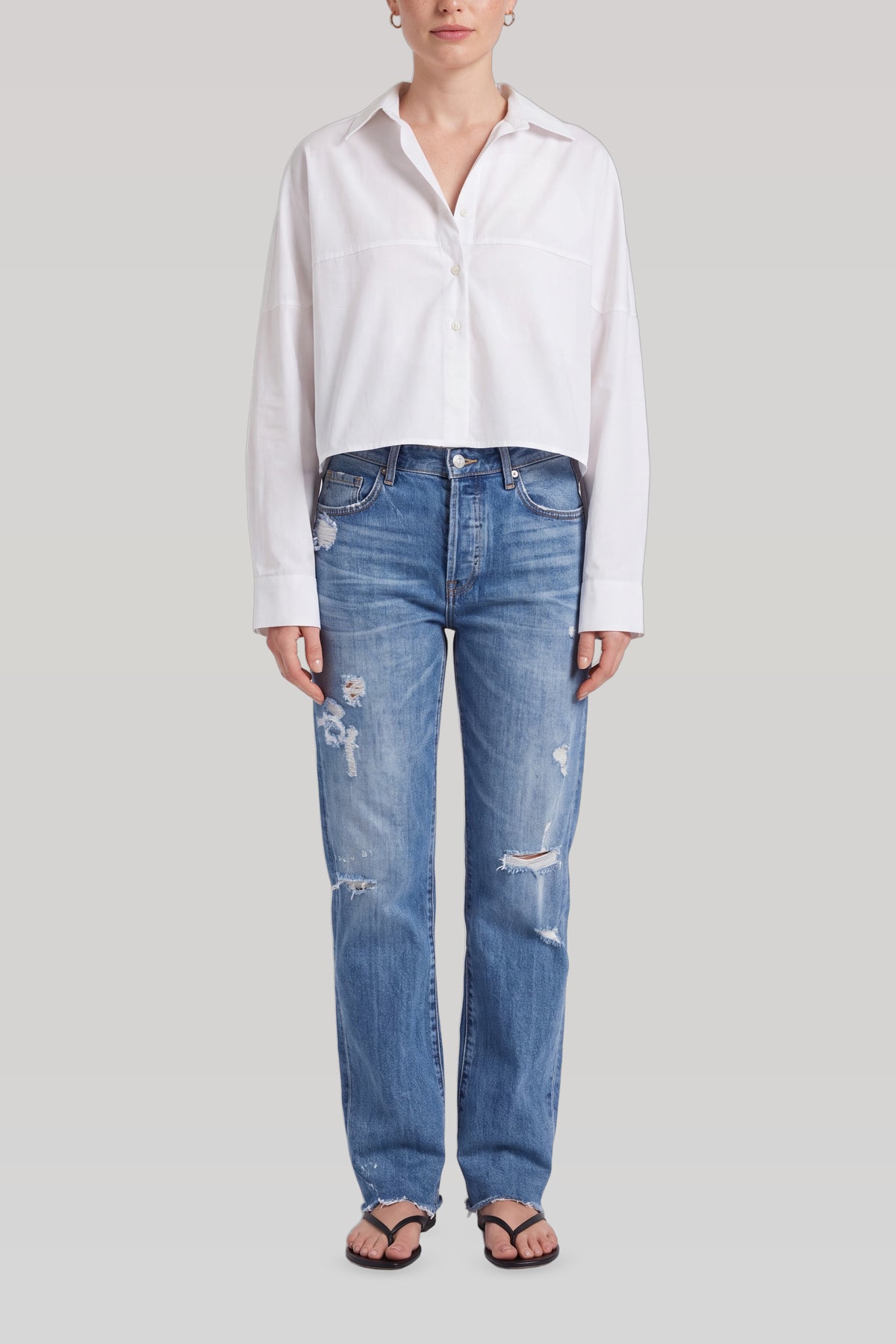 Blå ripped jeans dame set forfra med knaplukning og slidte detaljer