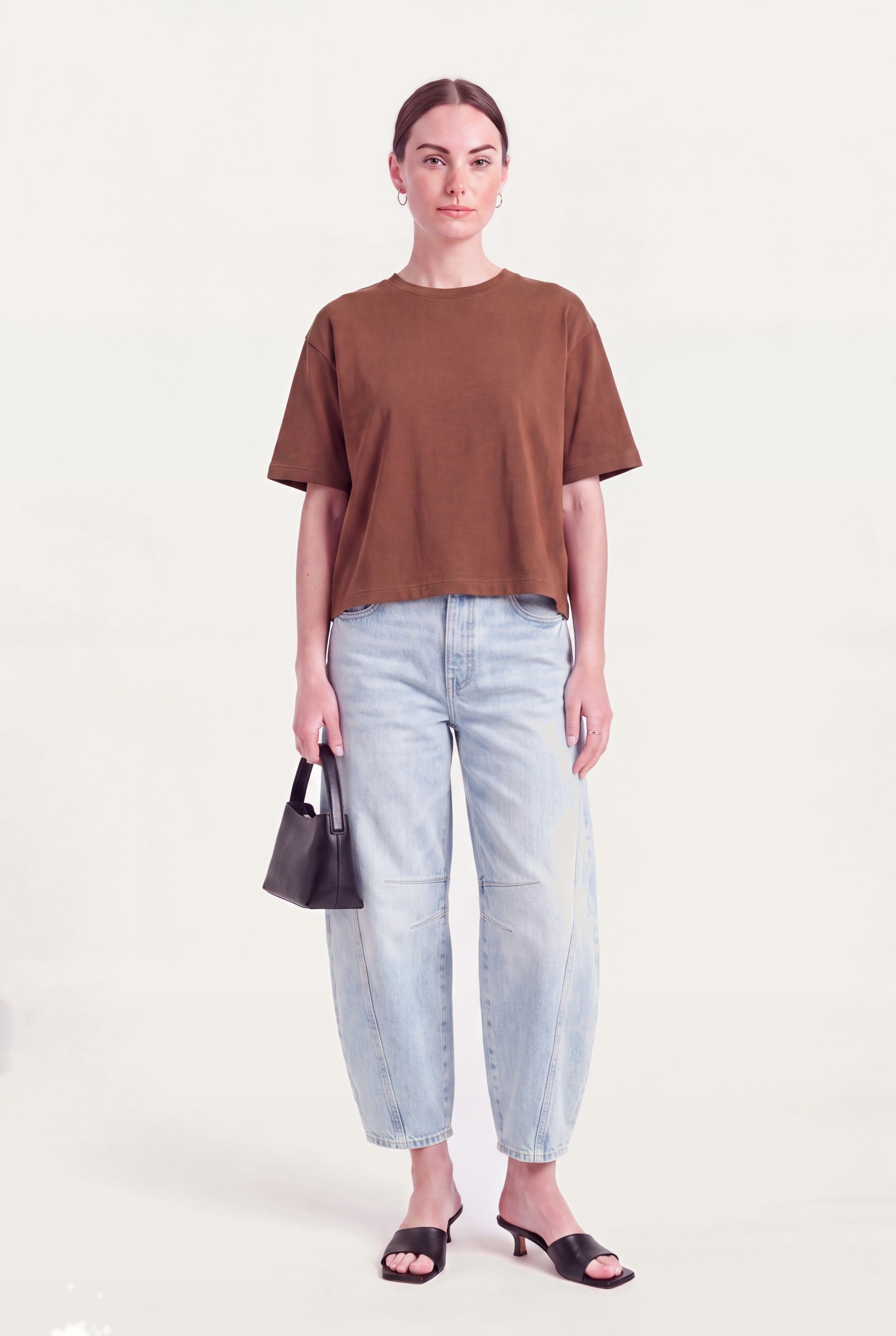 Barrel leg jeans dame i lyseblå denim styles med brun top, lille taske og hæle