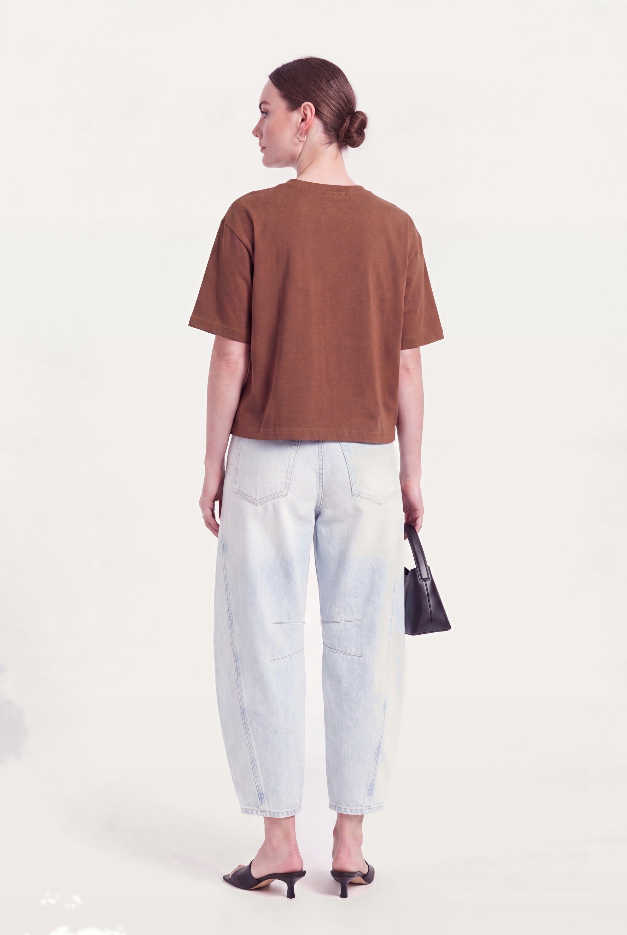 Barrel leg jeans dame i lyseblå denim set bagfra styles med brun top og hæle