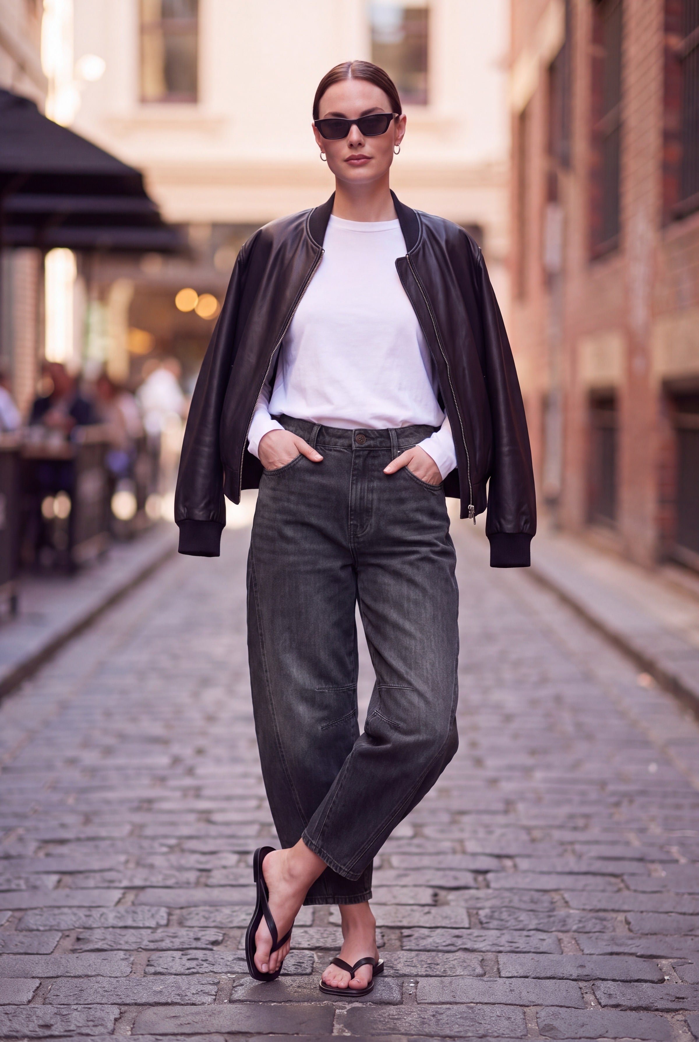 Barrel leg jeans dame i sort denim styles med hvid T-shirt og sort læderjakke
